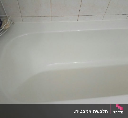 אמבטיה לבנה עם אריחי קרמיקה על הקיר